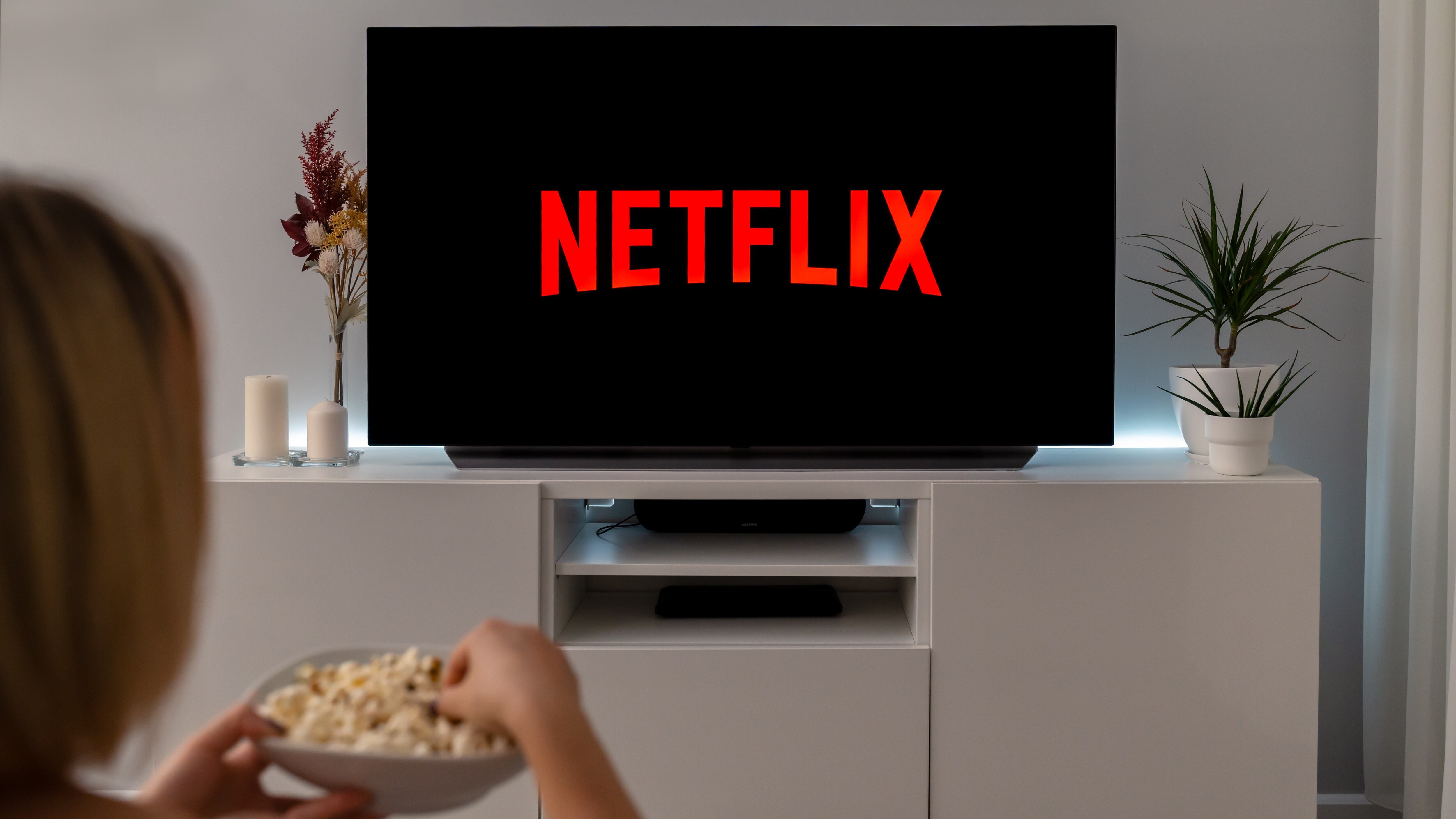 A woman watching Netflix, eating popcorn.